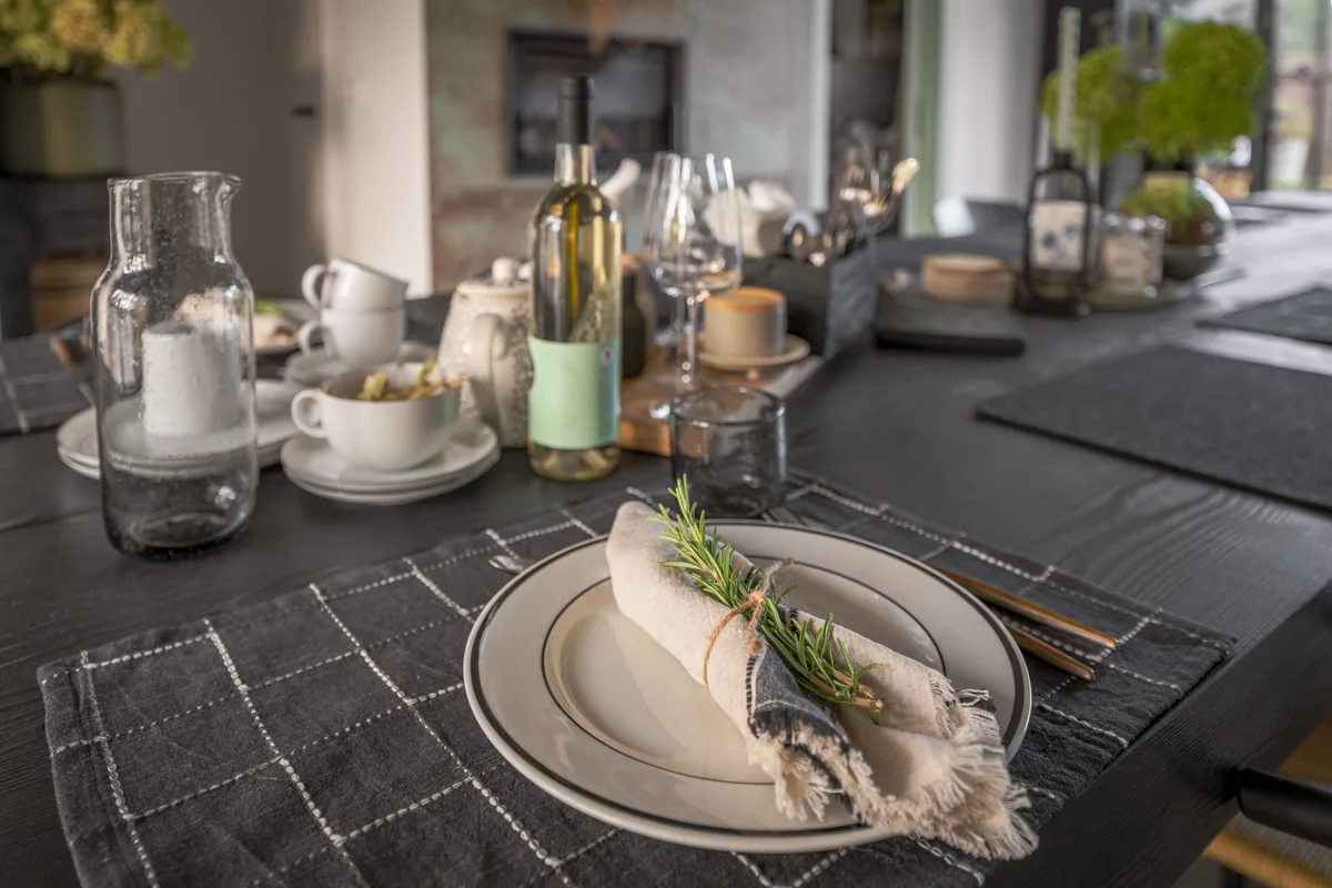 Stůl připravený ke snídani s porcelánovým nádobím a čerstvými květinami